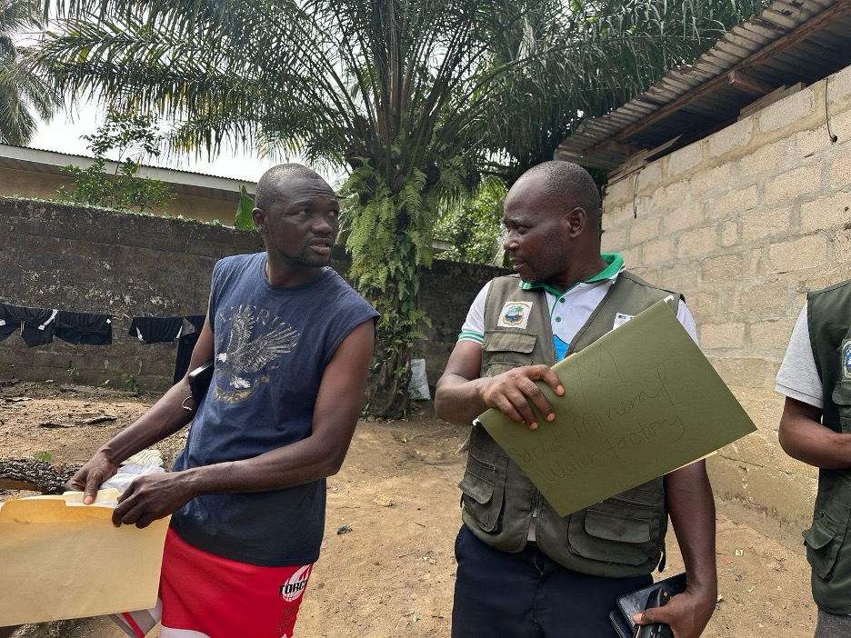 Environmental Protection Agency inspection team lead Stephens Gibson speaks with the operator of C3M Mineral Water Company as he issues the shutdown order.